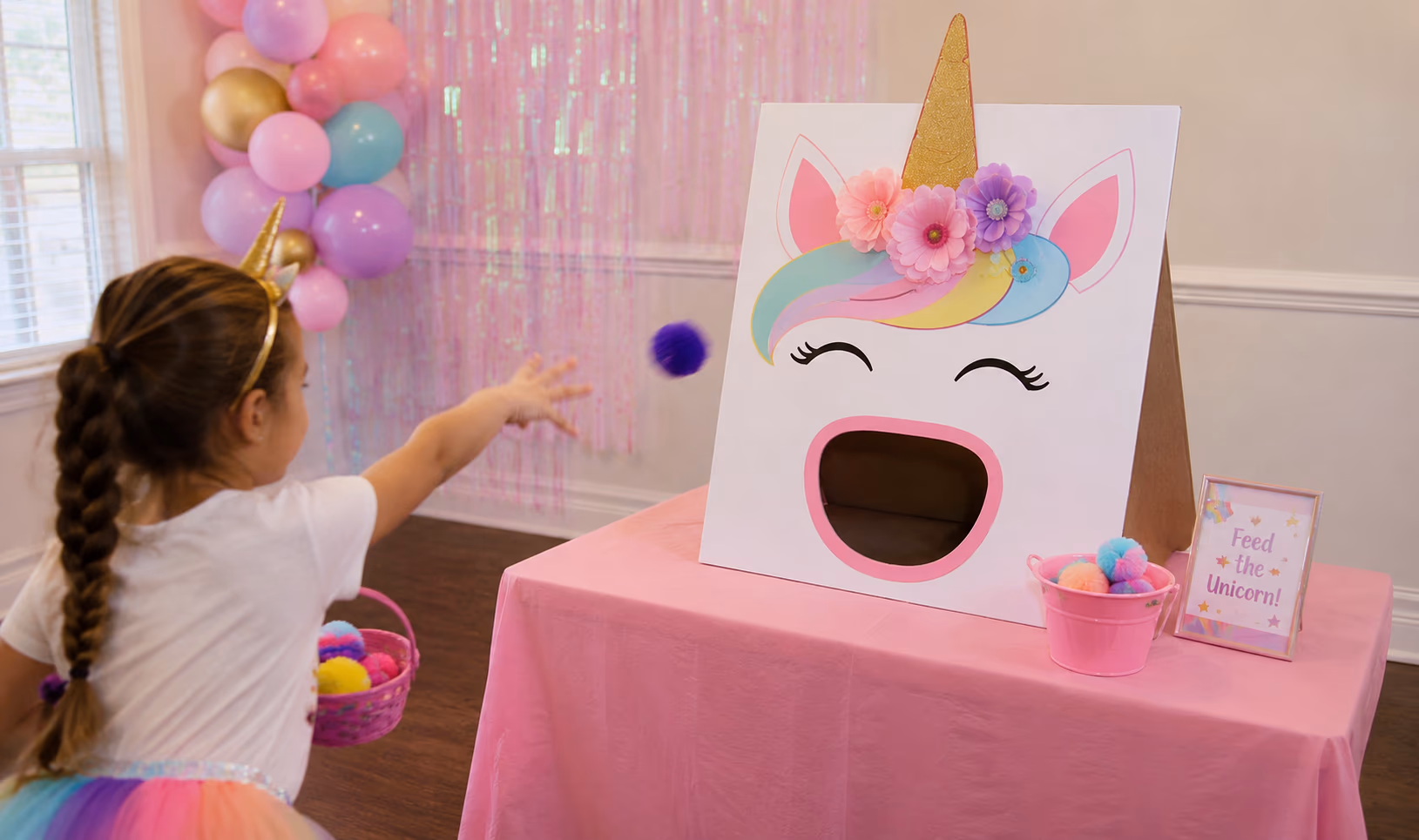 Unicorn toss game setup with a rainbow treat target and colorful beanbags